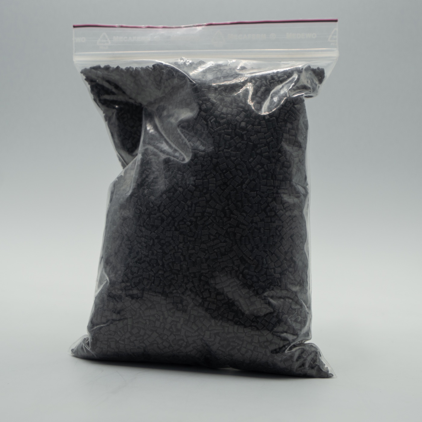 Sample bag filled with dark recycled-carbon thermoplastic pellets